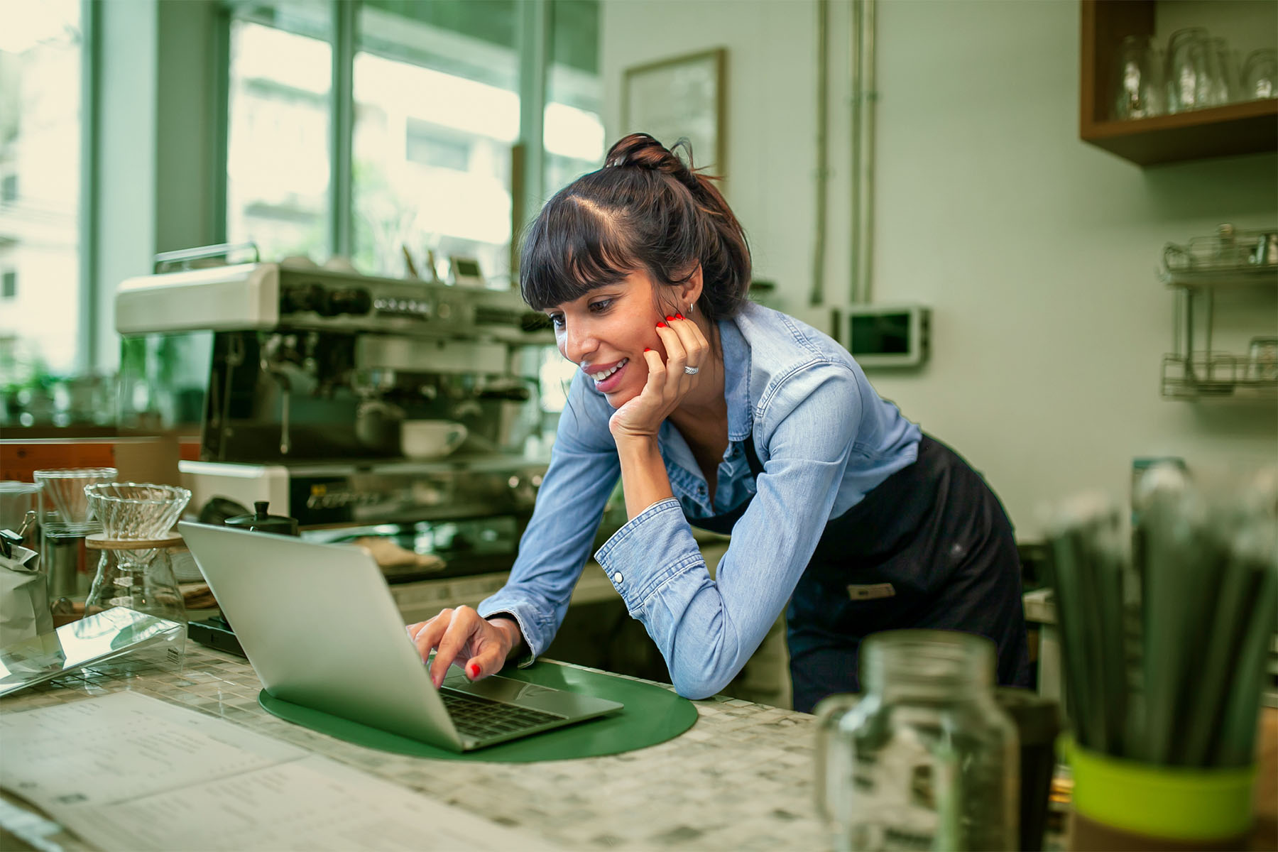 A small business owner comparing options on a laptop in her café